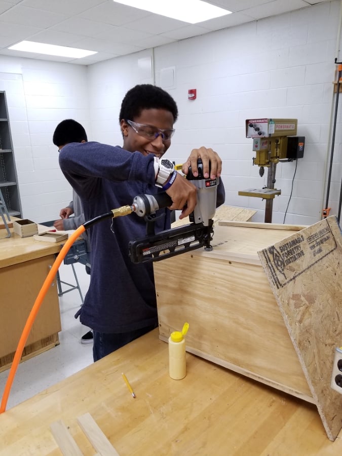 student creating a Free Little Library